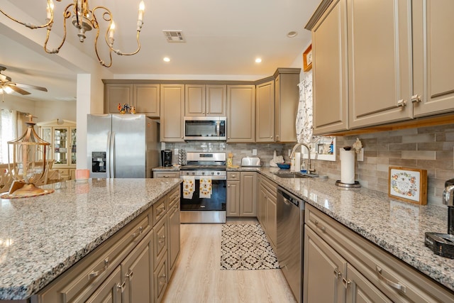 kitchen featuring visible vents, decorative backsplash, light wood-style flooring, appliances with stainless steel finishes, and a sink