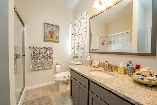 full bath with vanity, a shower stall, toilet, and wood finished floors