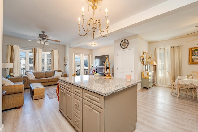 kitchen with a healthy amount of sunlight, a kitchen island, and light wood finished floors