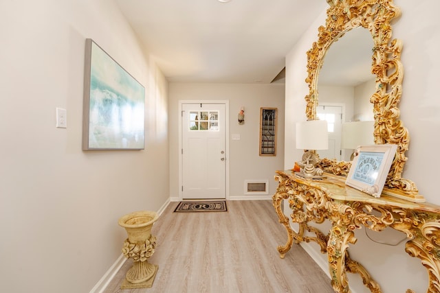 entrance foyer featuring visible vents, baseboards, and wood finished floors