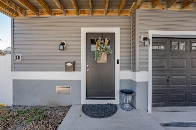 entrance to property with a garage and visible vents