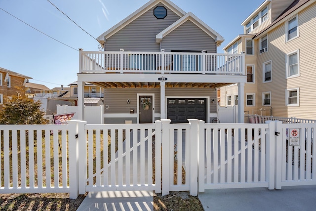 view of front facade with a fenced front yard, a gate, a porch, and a garage