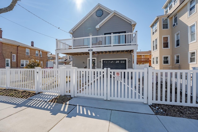 view of front of house with a garage, a fenced front yard, and a gate