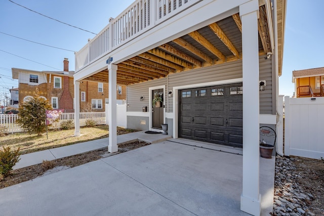 exterior space with a garage, fence, and concrete driveway