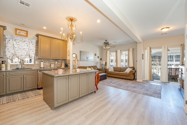 kitchen featuring a center island, tasteful backsplash, light wood-style floors, a sink, and dishwasher