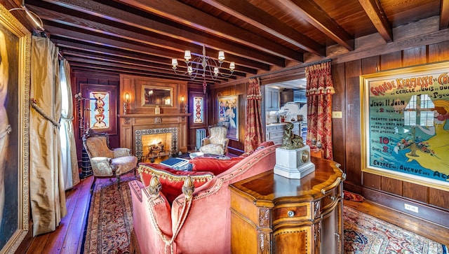 living room with beamed ceiling, wood walls, and wooden ceiling