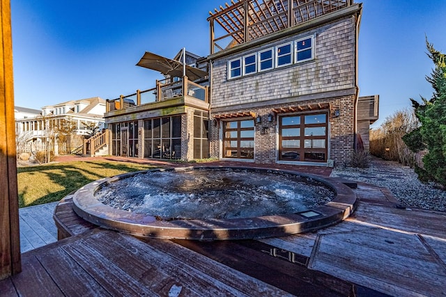 back of property featuring a wooden deck, a sunroom, and a balcony