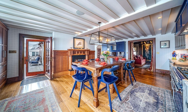 dining area featuring beam ceiling, a notable chandelier, and light wood-type flooring
