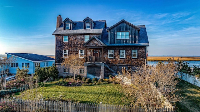 view of front of property with a front yard and a water view