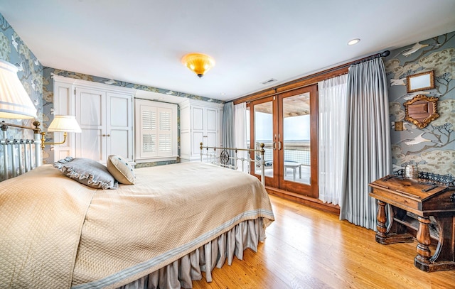 bedroom featuring light hardwood / wood-style flooring, access to outside, and french doors