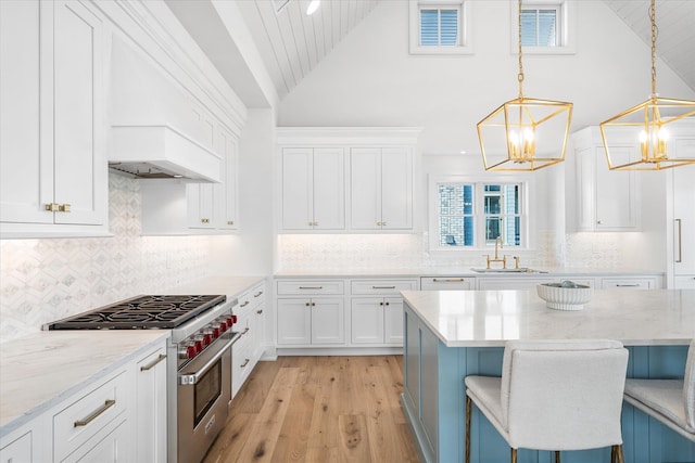 102 102nd St, Stone Harbor, NJ 08247 - kitchen with high end stainless steel range, a chandelier, a sink, white cabinets, and high vaulted ceiling