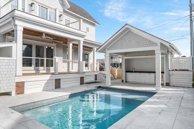 102 102nd St, Stone Harbor, NJ 08247 - rear view of property featuring a balcony, exterior kitchen, a patio area, an outdoor pool, and a ceiling fan