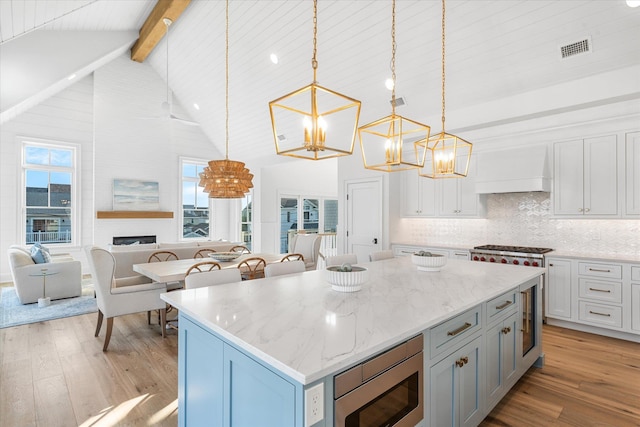 102 102nd St, Stone Harbor, NJ 08247 - kitchen featuring a chandelier, premium range hood, appliances with stainless steel finishes, beamed ceiling, and light wood-type flooring