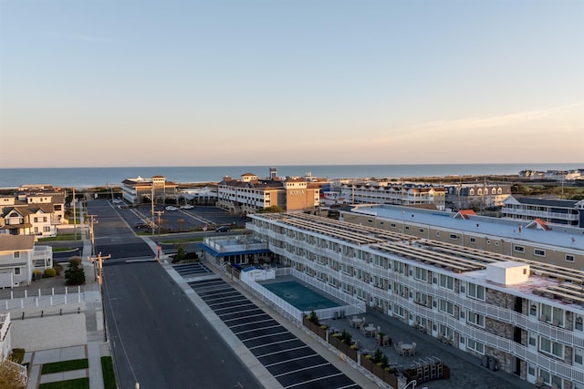 aerial view at dusk featuring a water view