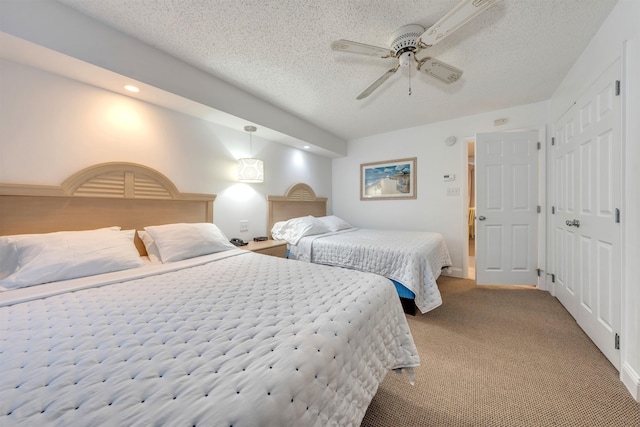 carpeted bedroom featuring a textured ceiling and ceiling fan