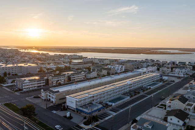 aerial view at dusk featuring a water view