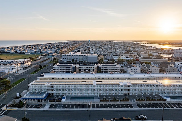 aerial view at dusk featuring a water view