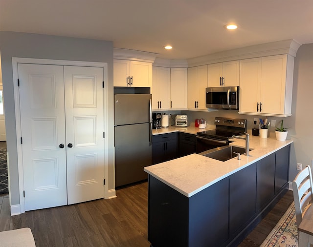 kitchen featuring white cabinetry, dark hardwood / wood-style floors, kitchen peninsula, and appliances with stainless steel finishes