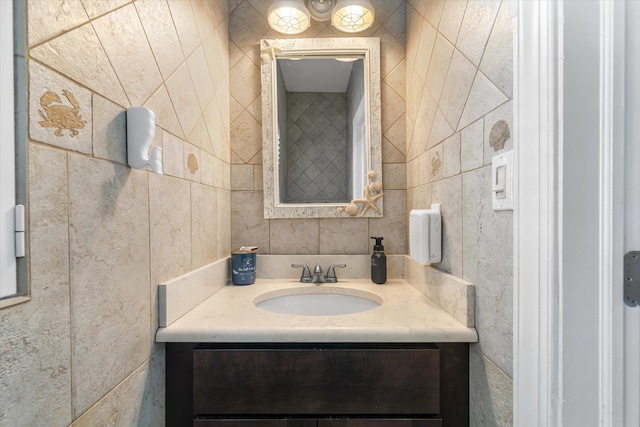 bathroom featuring vanity and tile walls