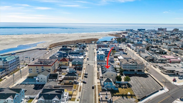 bird's eye view featuring a water view and a beach view