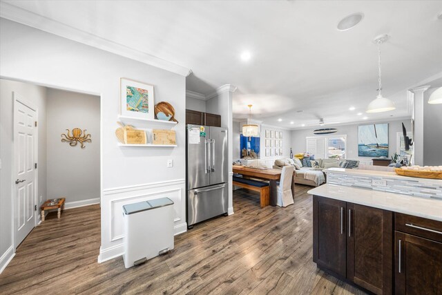 kitchen with dark wood finished floors, dark brown cabinetry, crown molding, and high end refrigerator