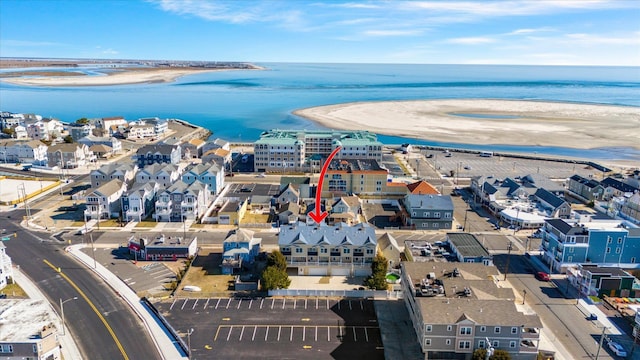 birds eye view of property with a water view and a beach view