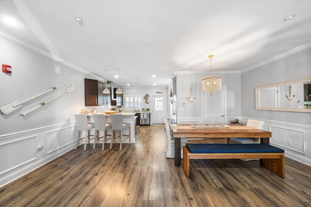 dining area with an inviting chandelier, crown molding, and dark wood-style flooring