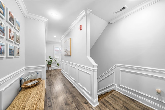 corridor featuring visible vents, ornamental molding, recessed lighting, wainscoting, and dark wood-style flooring
