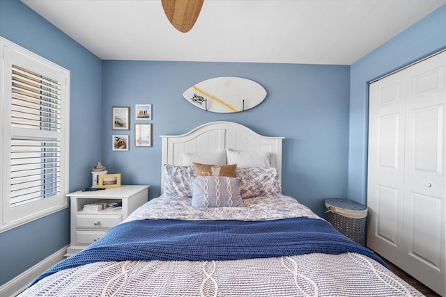 bedroom with a closet, a ceiling fan, and baseboards