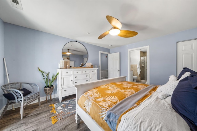 bedroom featuring visible vents, a ceiling fan, ensuite bath, wood finished floors, and baseboards