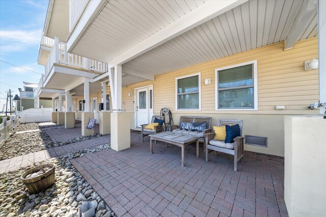 view of patio with a balcony and fence