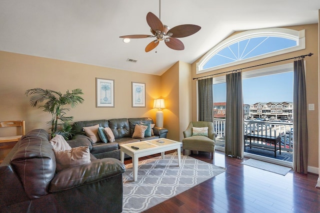 living room featuring vaulted ceiling, ceiling fan, and dark wood-type flooring