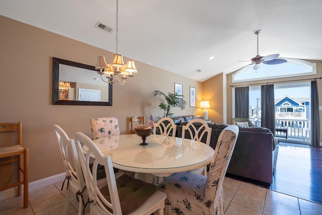 dining area with lofted ceiling, light tile patterned floors, and ceiling fan with notable chandelier