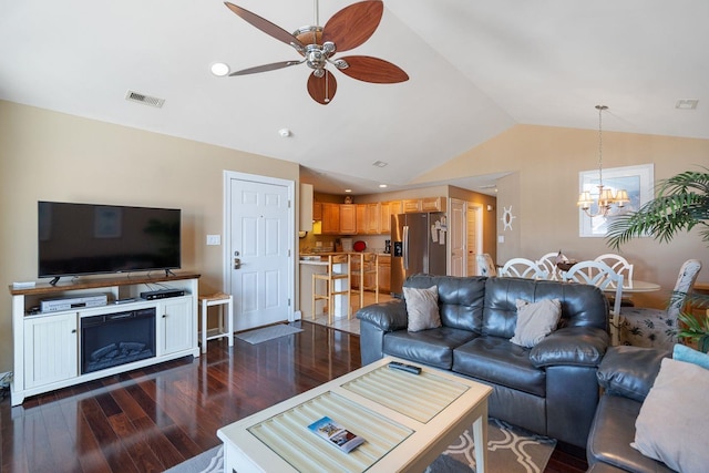 living room with ceiling fan with notable chandelier, dark wood-type flooring, and vaulted ceiling