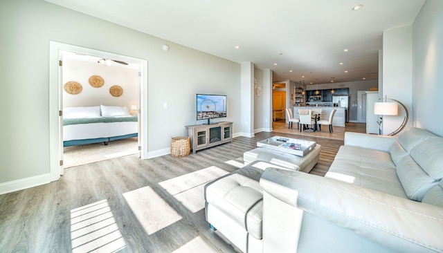 living area with light wood-type flooring, baseboards, and recessed lighting