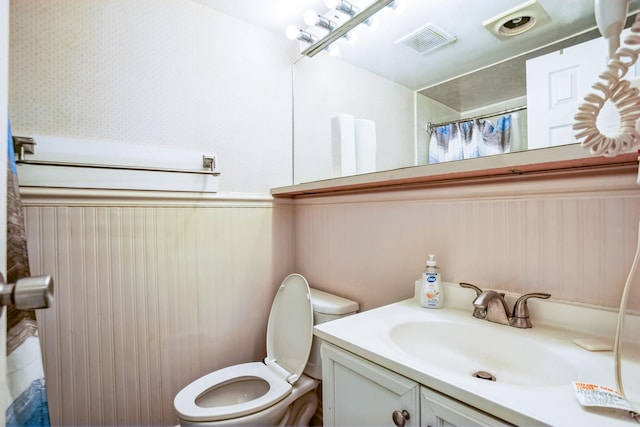 bathroom featuring walk in shower, vanity, and toilet