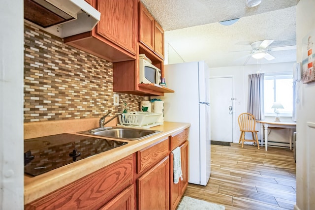 kitchen featuring sink, white appliances, ceiling fan, a textured ceiling, and decorative backsplash