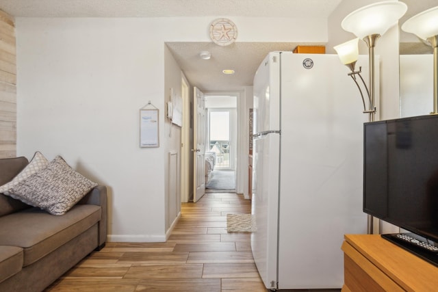 interior space with a textured ceiling and white refrigerator