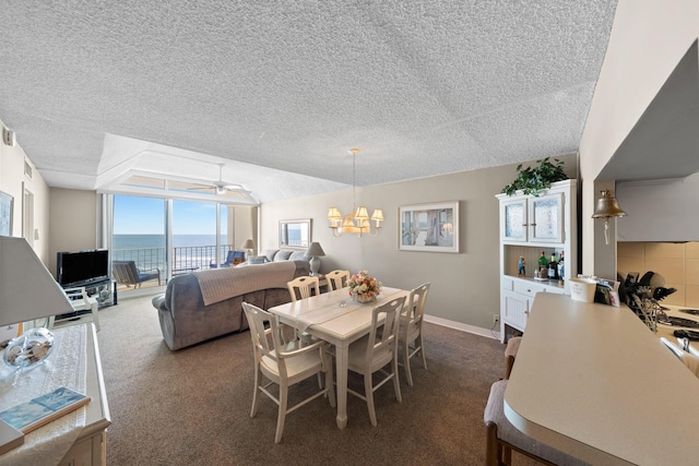 carpeted dining space featuring ceiling fan with notable chandelier, floor to ceiling windows, and a textured ceiling