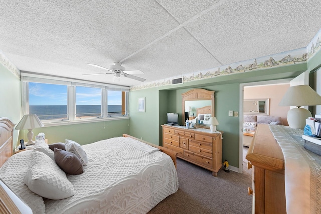 carpeted bedroom with ceiling fan and a water view