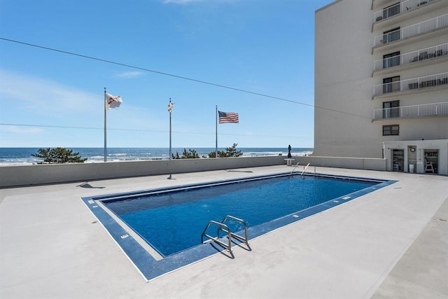 view of swimming pool with a water view