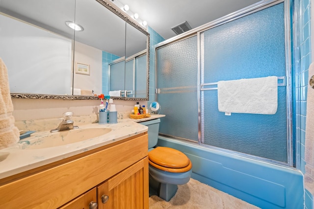 full bathroom featuring vanity, bath / shower combo with glass door, and toilet