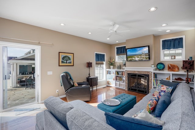 living room with hardwood / wood-style flooring, ceiling fan, and a premium fireplace