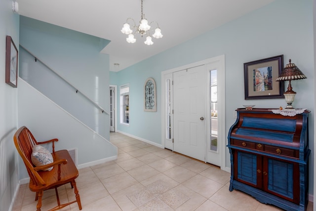 tiled entryway with a chandelier