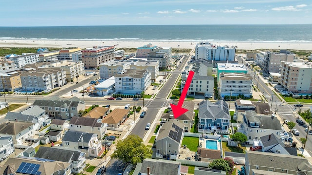 birds eye view of property featuring a water view and a beach view