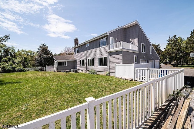 exterior space with a balcony, a yard, and central AC