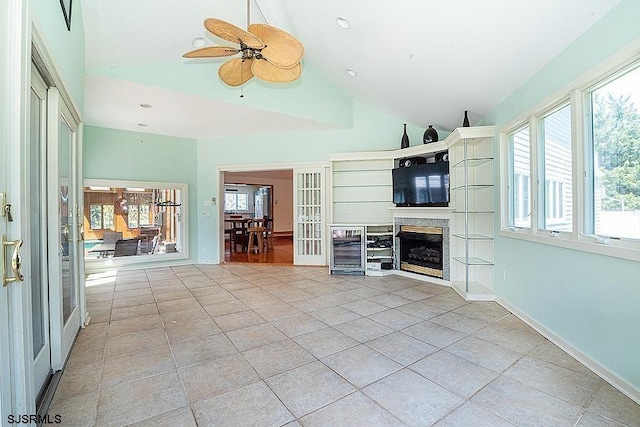 unfurnished living room featuring french doors, wine cooler, vaulted ceiling, and ceiling fan