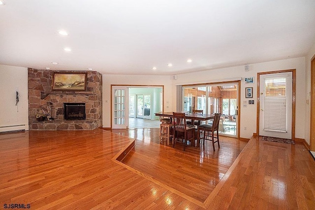 dining area with hardwood / wood-style flooring, a fireplace, and a baseboard radiator