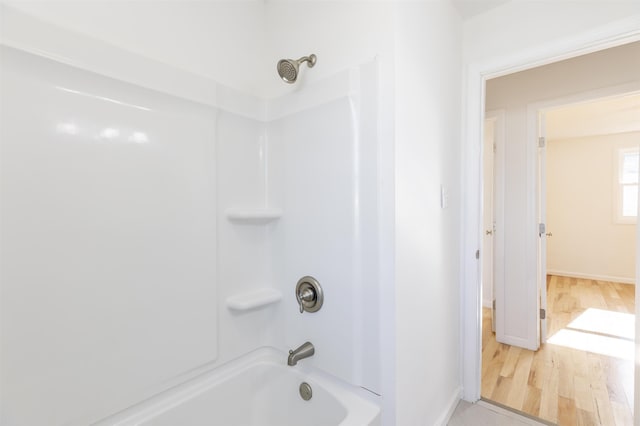 bathroom with wood-type flooring and  shower combination