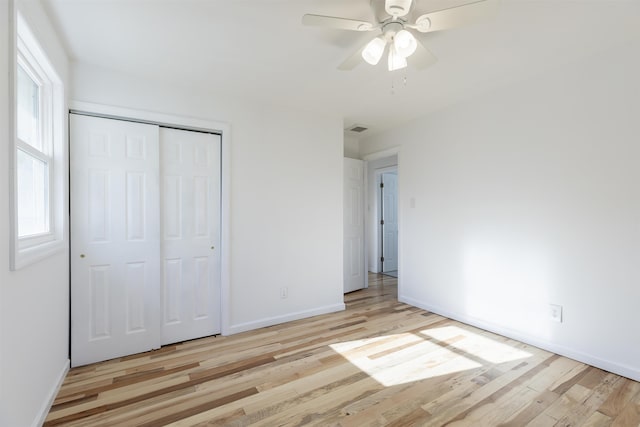 unfurnished bedroom featuring ceiling fan, light hardwood / wood-style flooring, and a closet